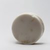 White colour round soap approx. 1 inch thick 3 inches across with a loofah inside the soap scented in Coconut cream